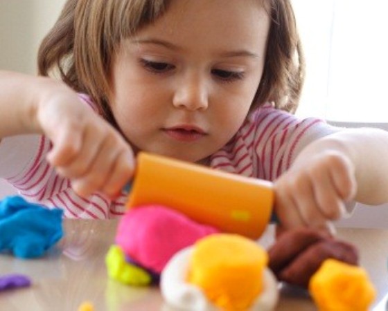 Little girl creating toys from play dough